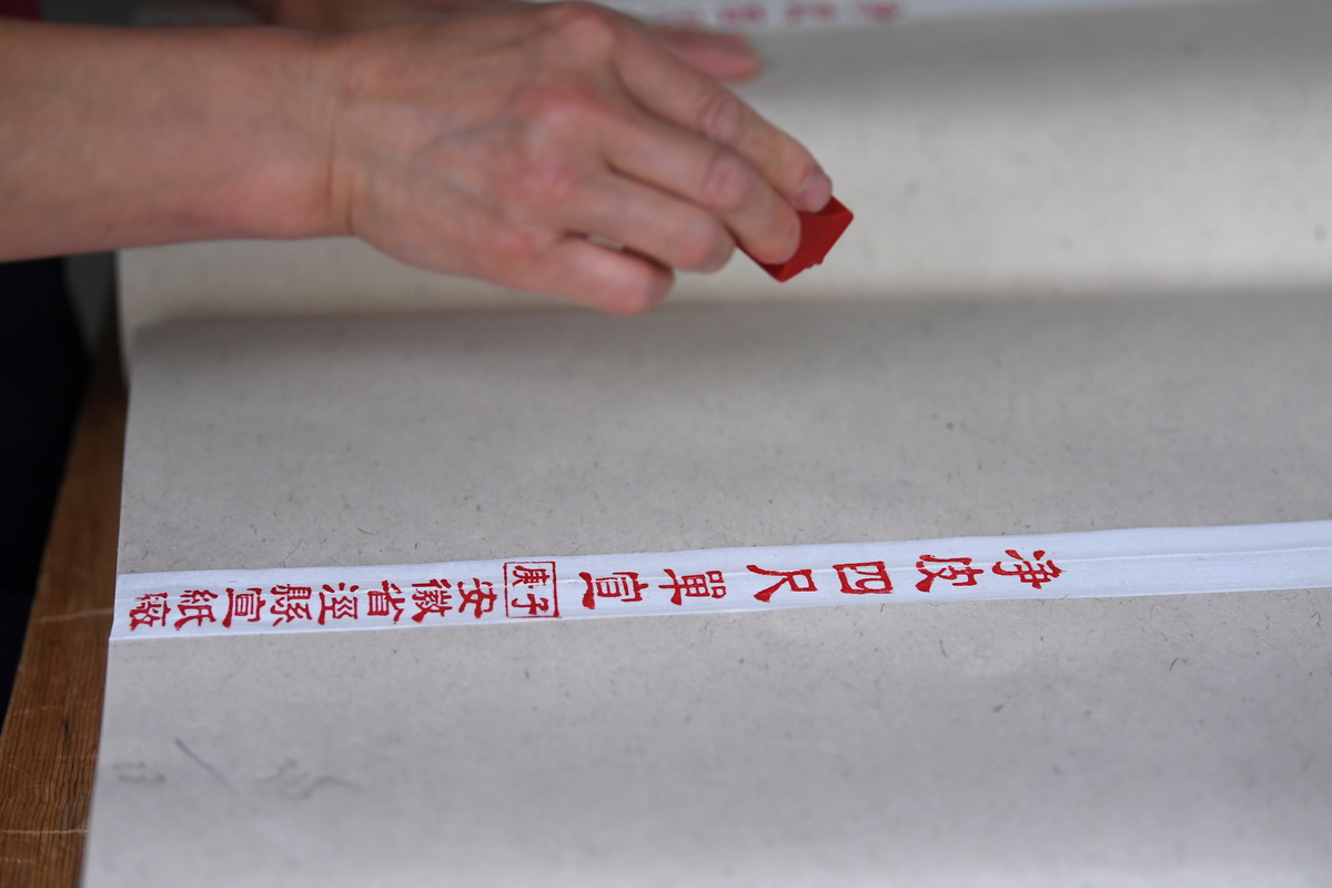5月11日，安徽省泾县宣纸厂工人为成品宣纸盖上印章。